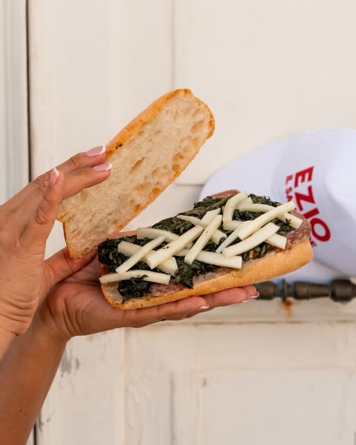 Panino con formaggio e verdure, staff con cappellino Ezio il Salumiere
